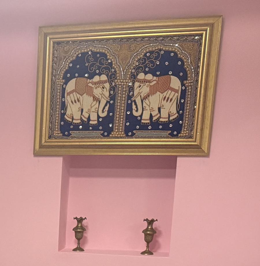 Framed Thai elephant tapestry above two small brass vases